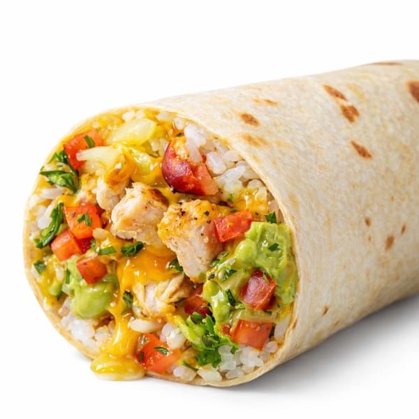 A chicken burrito, cut in half, filled with rice, cheese, guacamole, and diced tomatoes.