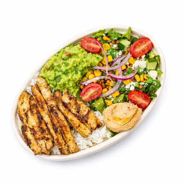 Grilled chicken, guacamole, hummus, rice, and salad with tomatoes, corn, and red onion.