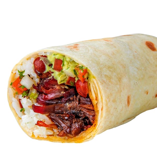 A large, cut burrito reveals a filling of rice, meat, guacamole, and salsa.